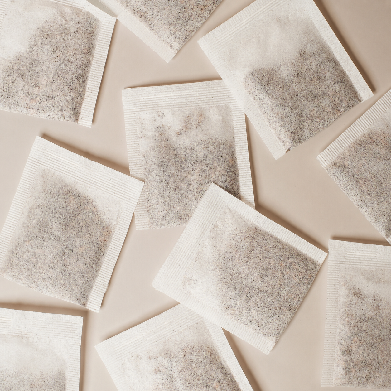 Several reusable pillow tea bags arranged on a light beige background.