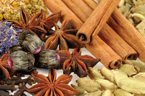 Assortment of dried spices: cinnamon sticks, star anise, and cardamom pods.