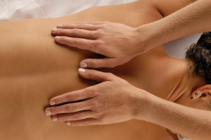 Close-up of hands performing a calming back massage.