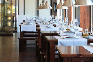 Interior of an empty restaurant dining room with set tables.