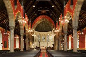 Interior of a large, ornate church or hall with rows of pews.